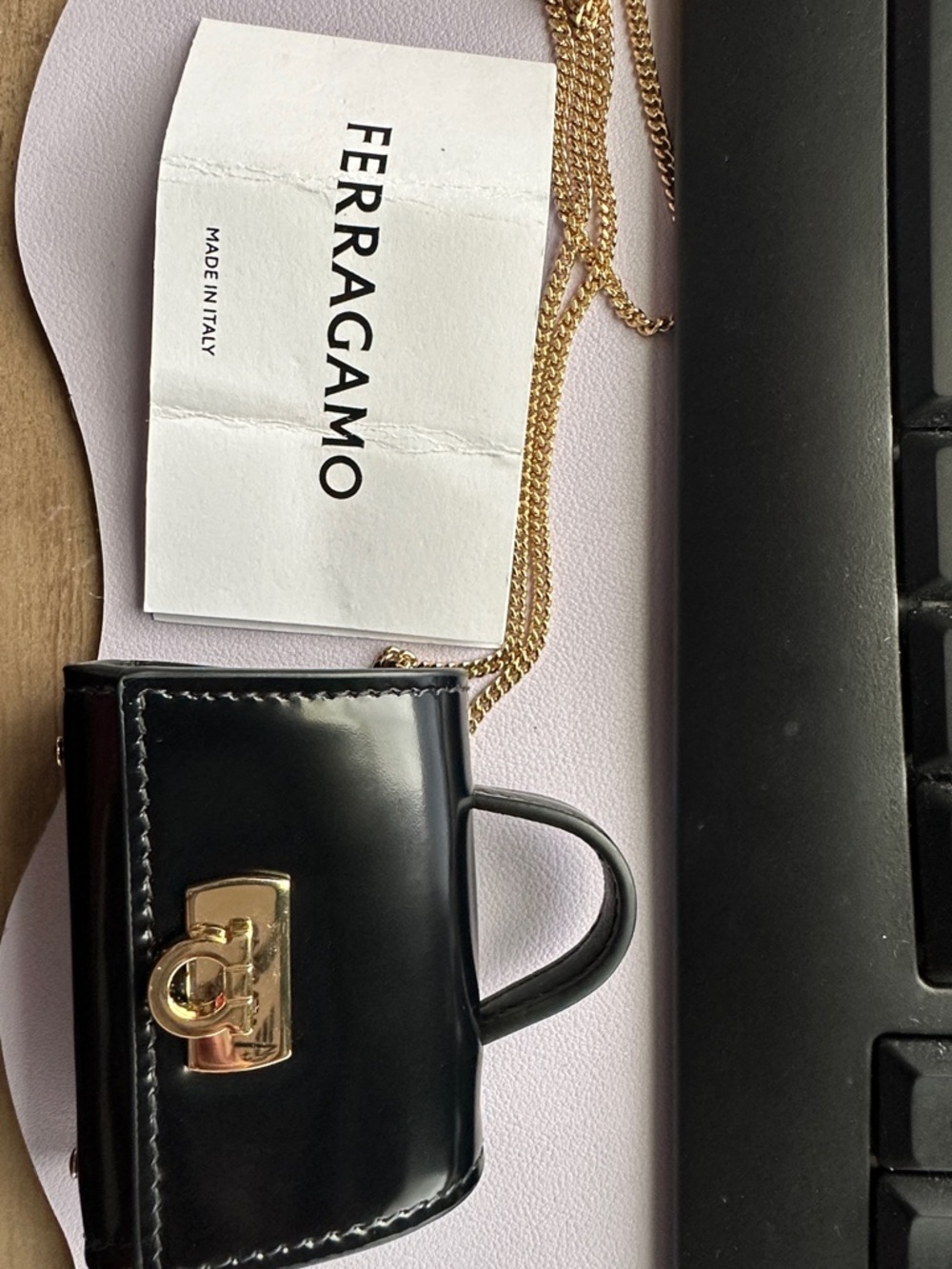 Salvatore Ferragamo Black Patent Mini Top Handle Bag for AirPods Pro’s.